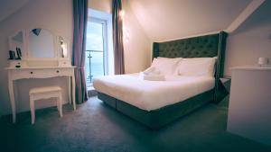 a bedroom with a bed and a table and a mirror at OYO Newquay Beach Hotel in Newquay