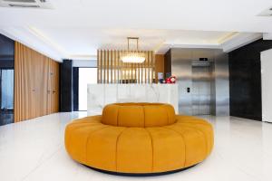 an orange ottoman in a room with a kitchen at Riva Hotel Alsancak in İzmir