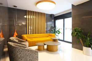 a living room with a yellow couch and a table at Riva Hotel Alsancak in İzmir