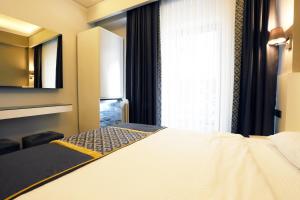 a hotel room with a bed and a window at Riva Hotel Alsancak in İzmir