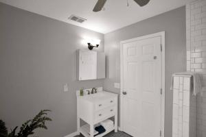 a white bathroom with a sink and a white door at 1940 cottage seen on FYI, 2bd 2ba in Gainesville