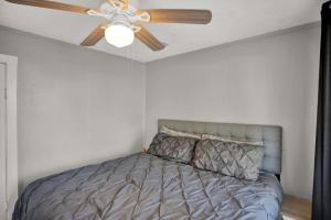 a ceiling fan in a bedroom with a bed at 1940 cottage seen on FYI, 2bd 2ba in Gainesville