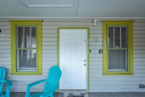 a house with yellow windows and a blue chair at 1940 cottage seen on FYI, 2bd 2ba in Gainesville