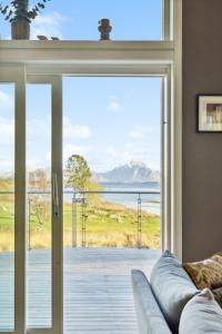 斯塔姆松Large villa in Lofoten with fantastic views - 4 bedrooms and 9 beds.的带沙发和大型玻璃门的客厅