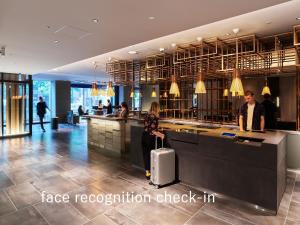 a hotel lobby with a woman with a suitcase at sequence KYOTO GOJO in Kyoto