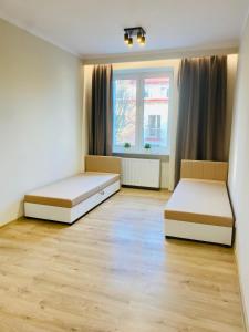 dwa łóżka w pokoju z dwoma oknami w obiekcie Gold Apartament w mieście Świdnik