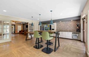 een keuken met een tafel en wat groene stoelen bij Extended Stay America Premier Suites - Miami - Airport - Miami Springs in Miami