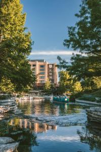 Un río con un edificio y un barco en el agua en Hotel Emma at Pearl on the Riverwalk, en San Antonio