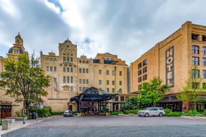 un gran edificio con coches estacionados en un estacionamiento en Hotel Emma at Pearl on the Riverwalk, en San Antonio