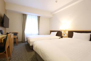 A bed or beds in a room at KOKO HOTEL Sendai Station South