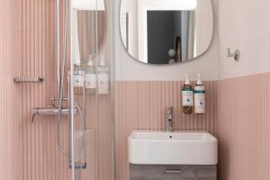 a bathroom with a sink and a shower with a mirror at Numa I Linea in Rome