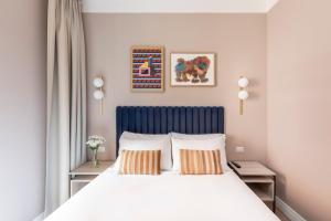 a bedroom with a bed with a blue headboard and two pillows at Numa I Linea in Rome