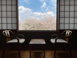 two chairs and a table in front of a window at 吉野荘湯川屋 Yoshinosou Yukawaya in Yoshino