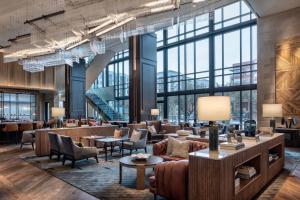 een lobby met banken, tafels en ramen bij Marriott Dallas Uptown in Dallas