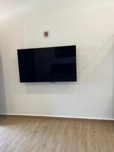 una TV a schermo piatto montata su una parete bianca di Raintown Cottage a Taiping