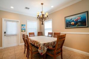 una sala da pranzo con tavolo e sedie di Coral Hammock Poolside Home a Key West