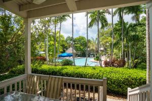 una veranda con vista sulla piscina e sulle palme di Coral Hammock Poolside Home a Key West