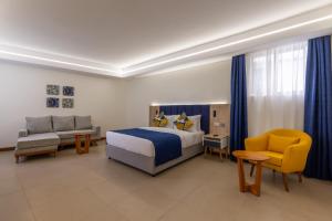 1 dormitorio con 1 cama, 1 sofá y 1 silla en Premium Inn Mombasa City, en Mombasa