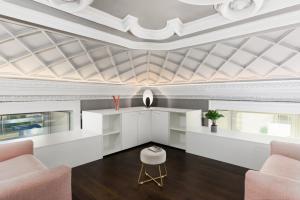 een woonkamer met een schuin plafond en roze stoelen bij Q71 TIMELESS SUITES in Turijn