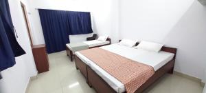 um pequeno quarto com 2 camas e uma janela em Mahadev Home Stay em Varanasi