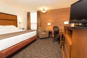 ein Hotelzimmer mit einem Bett und einem Flachbild-TV in der Unterkunft Drury Inn & Suites Frankenmuth in Frankenmuth