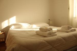 a white bed with towels on top of it at Hotel Al Verde in Mandello del Lario