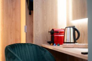 a red coffee maker sitting on a desk with a chair at Villa dei Larici in Camigliatello Silano