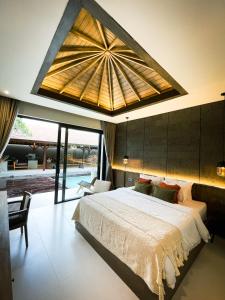 een slaapkamer met een groot bed en een groot plafond bij Luna Ola Villa Berawa in Canggu