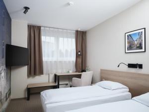 Pokój hotelowy z 2 łóżkami i biurkiem w obiekcie Iness Hotel w Łodzi