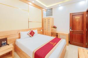 - une chambre avec un lit blanc et une armoire en bois dans l'établissement Ngọc Sang 1 Hotel, à Đà Lạt