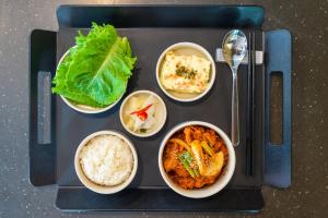 a tray of food with rice and different types of food at Parkavenue Guesthouse in Seoul