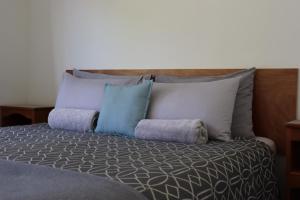 a bed with several pillows on top of it at Kanuka Ridge Lodge in Marahau