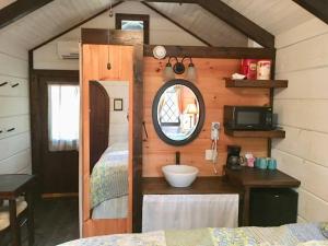 una camera con specchio e un letto in una stanza di Tiny Home Cottage Near the Smokies #10 Helena a Sevierville