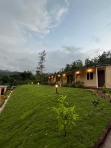 une cour avec une maison éclairée dans l'établissement VRISA Mountain Retreat, à Pune