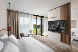 um quarto com uma cama grande e uma televisão na parede em Hotel Materra em Osijek