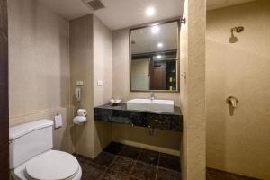 uma casa de banho com um WC, um lavatório e um espelho. em Patong Lodge Hotel - SHA Extra Plus em Patong Beach