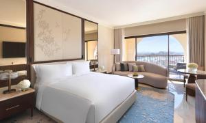 una camera con letto bianco e un soggiorno di The Ritz-Carlton Abu Dhabi, Grand Canal a Abu Dhabi