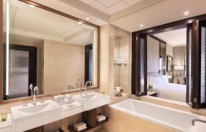 un bagno con due lavandini e un grande specchio di The Ritz-Carlton Abu Dhabi, Grand Canal a Abu Dhabi