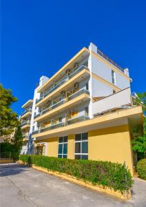 un edificio blanco y amarillo con arbustos delante en Park Hotel, en Atenas