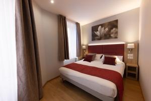 a bedroom with a large bed in a room at Hotel Saint Augustin in Strasbourg