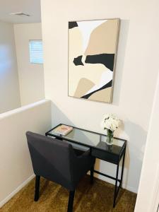 a black desk with a vase of flowers and a painting at 3BR King Suite/Near Strip/Wi-Fi in Las Vegas