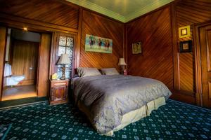 una camera con letto in una stanza rivestita in legno di Shady Rest Bed & Breakfast a Takaka