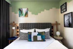 a bedroom with a bed with white sheets and pillows at Les Artistes in Paris