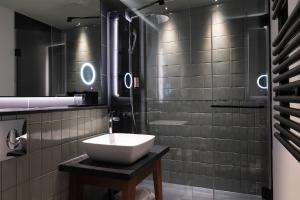 a bathroom with a sink and a shower at Les Artistes in Paris