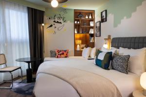 a bedroom with a large white bed with pillows at Les Artistes in Paris