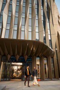 two people walking in front of a building at Canopy by Hilton London City in London