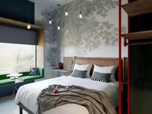 een slaapkamer met een groot bed en een groene stoel bij ibis Styles Copenhagen Orestad in Kopenhagen