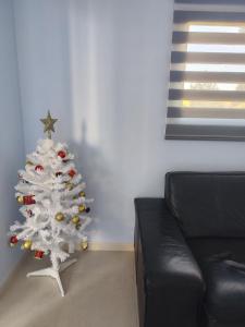 un árbol blanco de Navidad en una sala de estar con sofá en Paradise Village Port Aventuras, en Salou