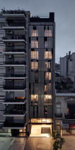 a tall building with lights on in a city at AQ Tailored Suites in Buenos Aires