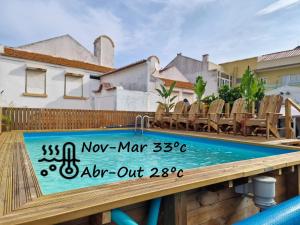 einen Pool mit Stühlen und ein Schild auf einer Terrasse in der Unterkunft Vila Maria Mix Dorm by HOST-POINT in Costa da Caparica